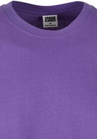 Tricou din bumbac mov, cu guler rotund, mânecă scurtă și etichetă inscripționată "URBAN CLASSICS", mărimea medie. Textură netedă și uniformă.