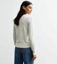 Ljusgrå stickad tröja med rund halsringning och ribbade ärmslut. I kombination med blå, högmidjade jeans. Enkelt, rent design.