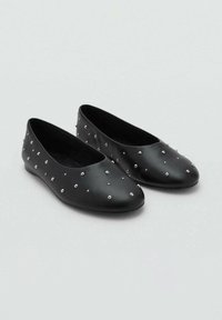 Schwarze Ballerinas aus glattem Leder mit runder Spitze, verziert mit kleinen silbernen Nieten auf der Oberfläche. Flache Sohle.
