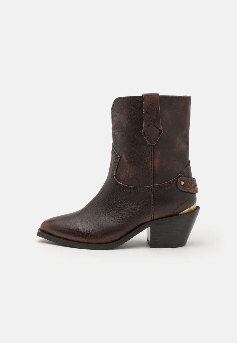 Botte de cowboy en cuir marron avec un bout pointu et un talon empilé. Présente un motif en losange décoratif et une sangle avec un accent en quincaillerie.