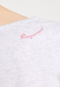 Biała koszula z krótkim rękawem o miękkiej fakturze, z różowym haftem "Raswear" z tyłu, blisko dekoltu.