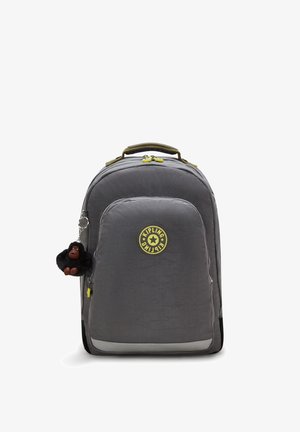 Mochila de nylon gris con una textura suave, un logo amarillo y un llavero de gorila negro. Cuenta con cremalleras amarillas y un bolsillo lateral.