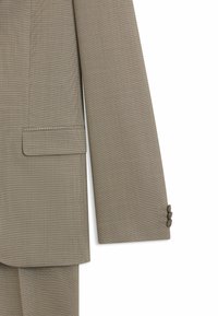 Chaqueta de traje marrón claro con un tejido texturizado y un patrón sutil, abertura trasera simple y detalles de puño con tres botones.