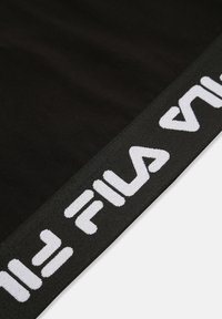 Svart tyg med vit Fila-logga längs kanten. Har en slät textur och en enhetlig, rakt klippt design.