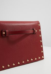 Dorothy Perkins Taška s příčným popruhem - dark red