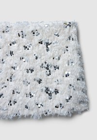 Tessuto bianco testurizzato con paillettes argento sparse qua e là. Aspetto sfocato e morbido, con bordi frangiati. Dimensioni non specificate.