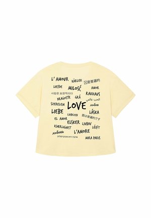 Geel katoenen T-shirt met "LOVE" in verschillende talen in vette zwarte tekst, met extra kleinere tekst, losse pasvorm en korte mouwen.