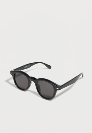 Fekete kör alakú szemüveg sötét lencsékkel és vékony szárakkal, a belső oldalon "PIER ONE" felirattal.