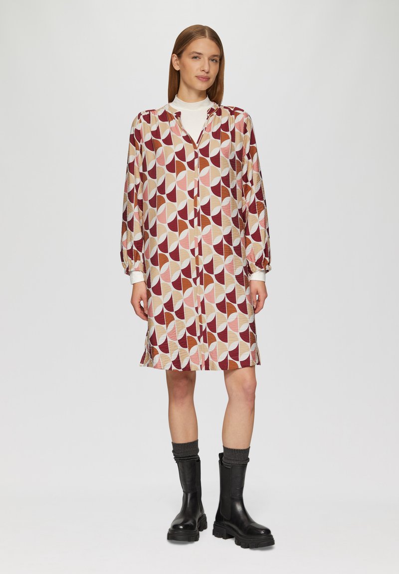 Langsleeve, knoop-up jurk met een geometrisch patroon in maroon, beige en roze. Gemaakt van een lichtgewicht stof, met een kraag en manchetten.