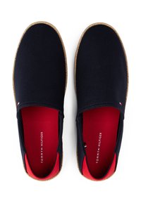 Marinierscanvas instap schoenen met een rode binnenkant en een geweven juten zool. Kenmerkt zich door minimale branding en elastische zijpanelen voor eenvoudig aan- en uittrekken.