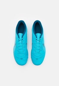 Botas de fútbol turquesa con una textura suave, forma redondeada, cordones en tonalidad y un diseño elegante que presenta una marca y patrones impresos.