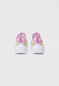 Un paio di sneaker bianche con accenti rosa e verdi viste da dietro su uno sfondo bianco uniforme.