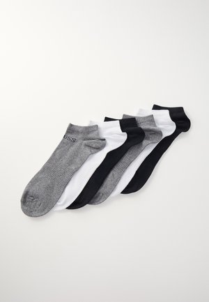 Cinco pares de calcetines cortos en negro, blanco y gris. Presentan una textura acanalada y una tela suave, con un logo en el calcetín gris.