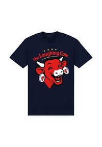 Námořnické tričko s velkým červeným karikovaným kravským motivem, která má široký úsměv, náušnice a nad ní je text "The Laughing Cow" s hvězdami ve žluté barvě.