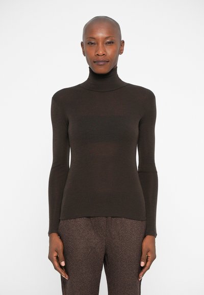 Pull à col roulé marron avec des manches longues, fabriqué dans un matériau doux et légèrement texturé. Design ajusté. Associé à un pantalon marron à motifs.