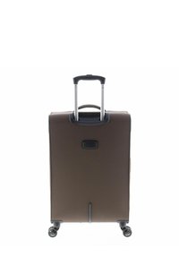 Valigia rigida color marrone scuro con manico telescopico, due ruote e area per etichetta bagaglio frontale. Texture liscia, forma rettangolare.
