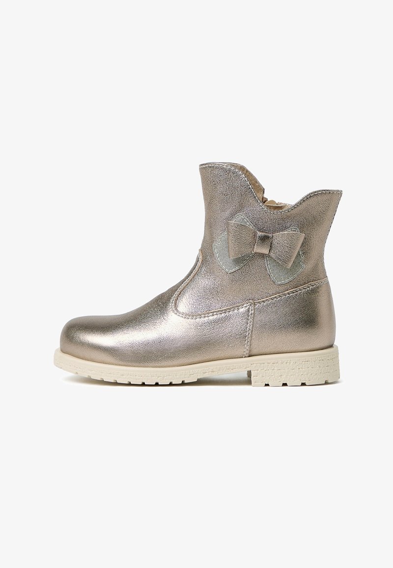 Bottines en cuir doré métallique avec un haut à bords festonnés, un nœud décoratif sur le côté et une semelle texturée blanche. Surface en cuir lisse.