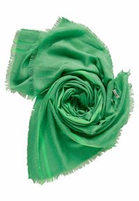 Écharpe verte à bords frangés avec de subtiles paillettes dorées, roulée en spirale sur un fond blanc, avec une étiquette de marque visible.