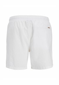 Shorts blancs à taille élastique avec une poche arrière unique et une petite étiquette logo marron sur le côté droit.