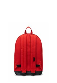 Sac à dos en tissu rouge avec un dos rembourré, des bretelles réglables et une bordure inférieure noire équipée de deux fermoirs. Forme compacte et arrondie.