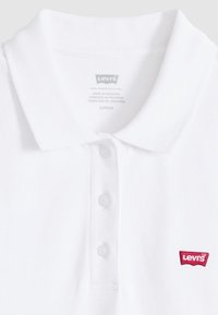 Polo blanc Levi's avec col et trois boutons, arborant un petit logo rouge Levi's sur le côté droit à l'avant.