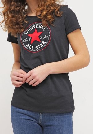 Camiseta de algodón negra con un gráfico de estrella roja que incluye el texto "CONVERSE ALL STAR" y "Chuck Taylor", de manga corta y ajuste slim.