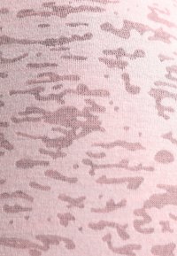 Jasnoróżowa tkanina z subtelnym, abstrakcyjnym, brązowym wzorem tekstury, zawierająca nieregularne faliste kształty o różnej przezroczystości.