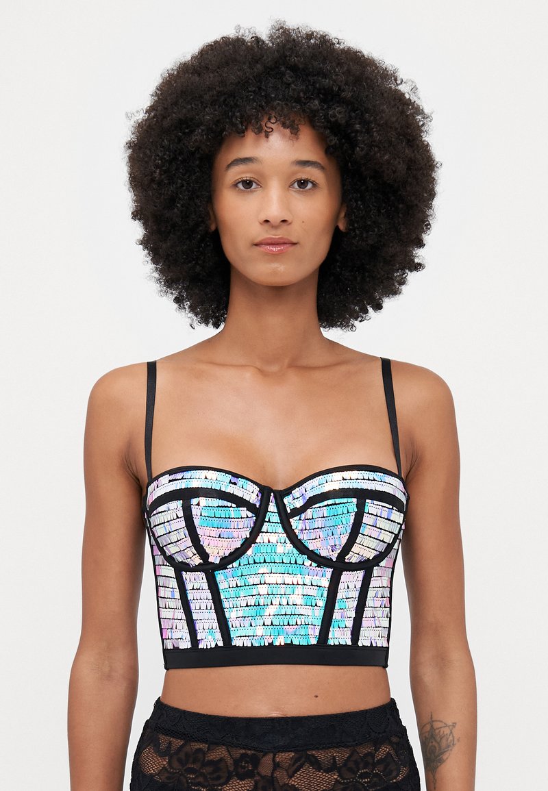 Hohtoherkullinen paljettitrikoo crop-top mustilla yksityiskohdilla, rakenteellinen korsettimallinen muotoilu, ohuet olkaimet ja monimutkainen geometrinen kuvio.