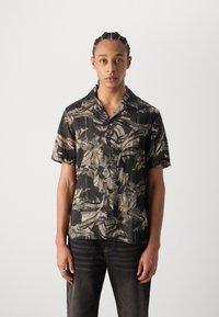 Camicia a maniche corte nera con un motivo astratto testurizzato che presenta dettagli grigi e gialli. Design con bottoni e vestibilità rilassata.