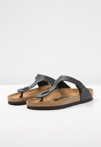 Černé thong sandály s texturovanou korkovou stélkou, matným povrchem a kulatým akcentem na popruhu. Lehký a plochý design.