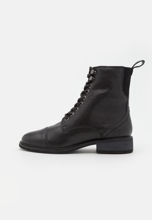Black leather ankle boot with lace-up front, rounded toe, pull tab at heel, and low stacked heel against a plain white background.