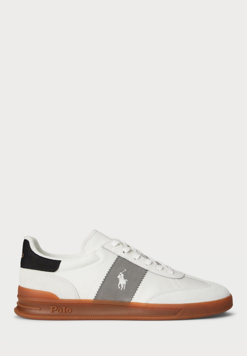 Basket basse blanche avec semelle marron, panneau latéral gris, détail talon noir et logo Polo blanc sur le côté.