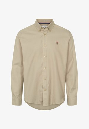 Beige pikkade varrukatega nööpidega särk, millel on point krae, kaks rinna nööpi ja väike tikand logo vasakul külje peal. Pehme tekstuur.