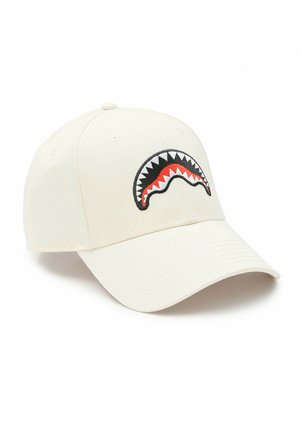 Cappellino da baseball color avorio con visiera curva che presenta un disegno ricamato della bocca di uno squalo in nero, bianco e rosso sul pannello frontale.