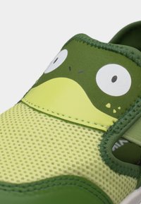 Kindergrüner und gelber Schuh mit Netzstruktur und Cartoon-Froschgesicht-Design im Zehenbereich.