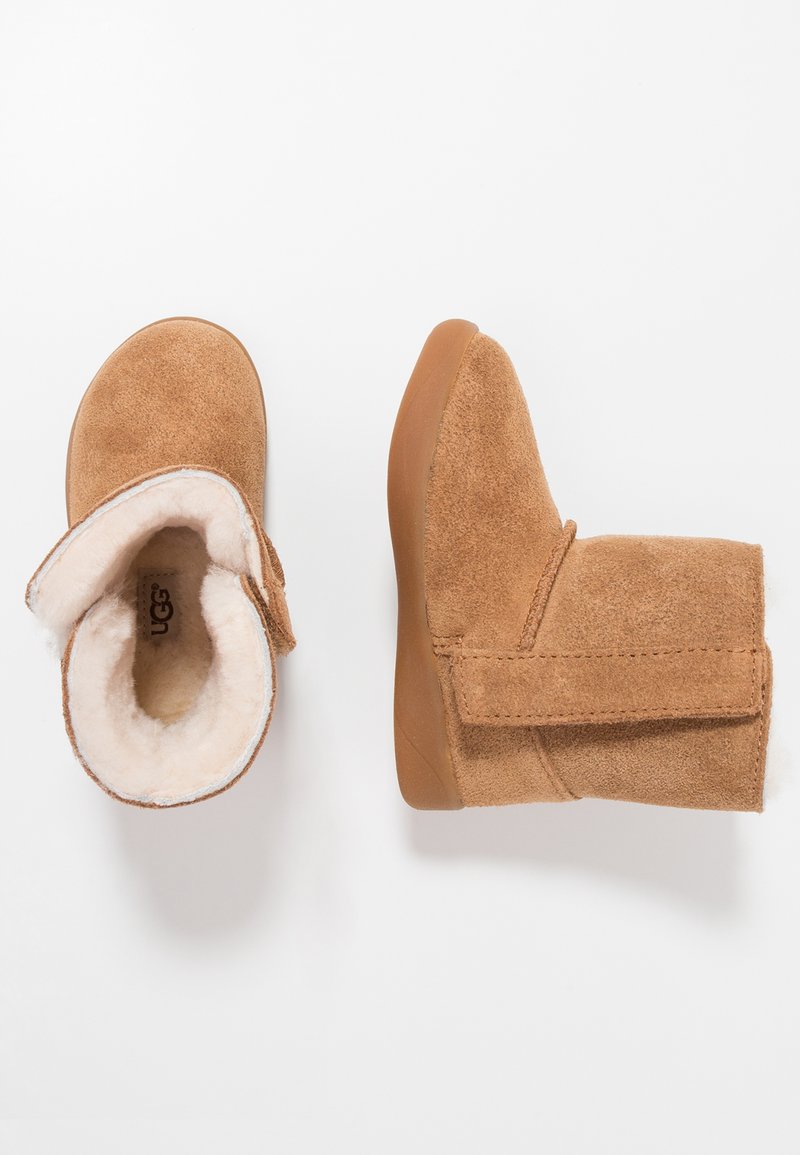 Bottes chelsea en nubuck beige avec une doublure douce et moelleuse et une fermeture à bande Velcro. Présentent un bout arrondi et une semelle en caoutchouc flexible.