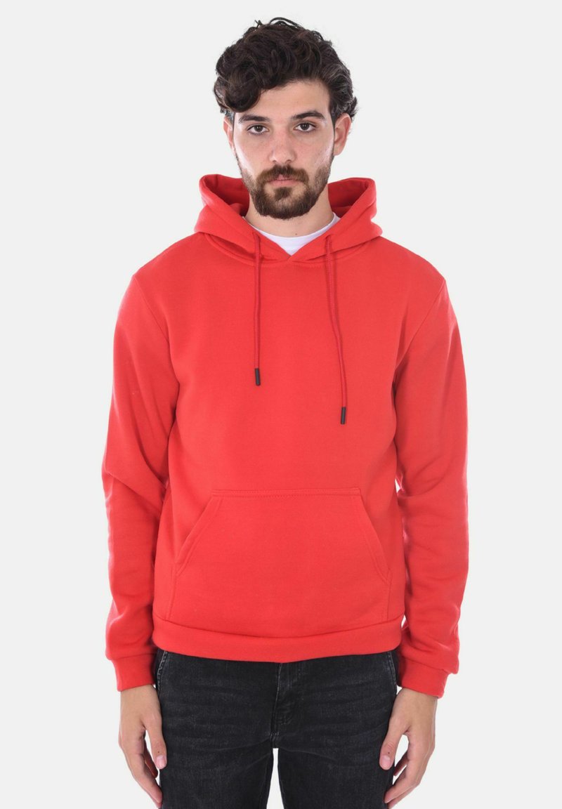 Felpa rossa realizzata in morbido tessuto, con tasca frontale, cordini e vestibilità rilassata. Abbinata a jeans scuri.