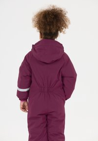 Lilla vandtæt sn suit med hætte, elastisk talje og reflekterende striber på ærmerne. Glat tekstur, designet til koldt vejr.