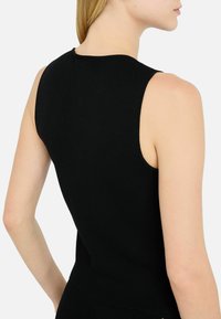 Black ribbed sleeveless top featuring a round neckline and fitted design. Smooth texture, clean lines, and minimalistic style.