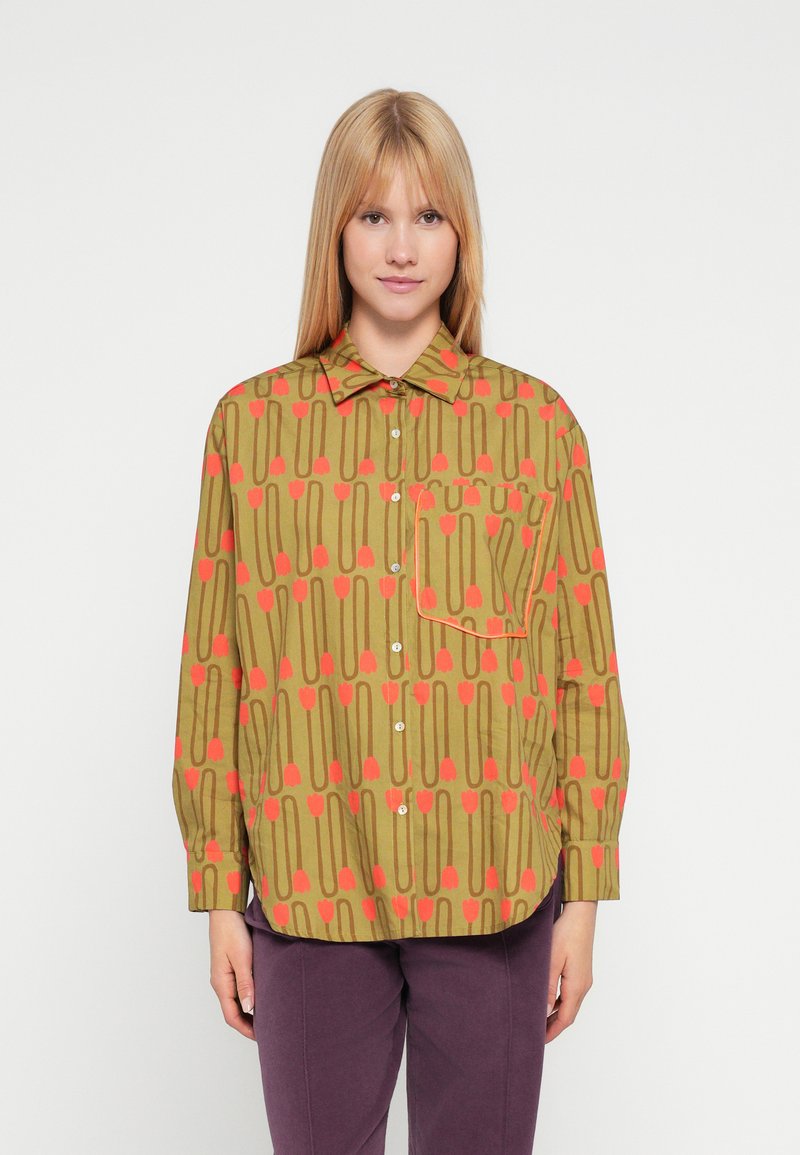 Πουκάμισο με μακριά μανίκια σε ελιά πράσινο χρώμα με γεωμετρικό μοτίβο κόκκινων τουλίπων και γραμμών. Διαθέτει μια τσέπη και στρογγυλεμένη ραφή στο τελείωμα.