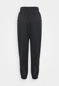 Černé tepláky s elastickým pasem, manžetami u nohou a bočními proužky. Vyrobené z měkké látky s hladkým povrchem.