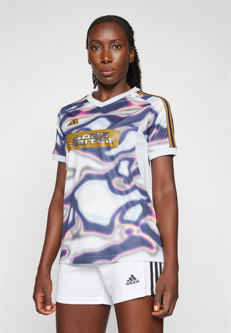 Bunt gestreiftes Sporttrikot mit Wellenmuster, goldenen Akzenten, Rundhalsausschnitt und Adidas-Logo, kombiniert mit weißen Shorts.