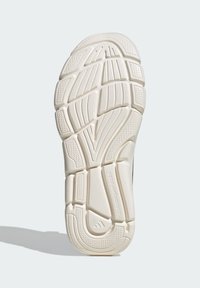 White rubber shoe sole with textured patterns and grooves. Features include a padded heel, geometric shapes, and a logo at the bottom.