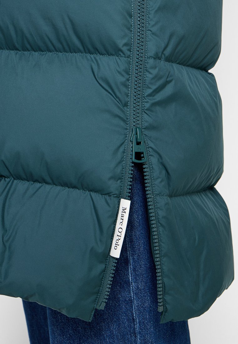 Grüne Pufferjacke mit glatter Textur, ausgestattet mit einem Reißverschluss vorne und einem weißen Etikett mit dem Markennamen.