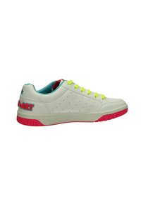 Sneaker bianco con tomaia perforata, lacci giallo neon e suola rosa. Presenta un rivestimento turchese e un branding ricamato multicolore.