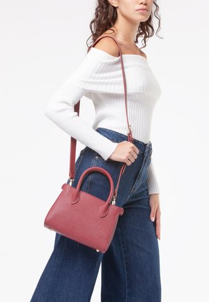 Borsa in pelle bordeaux con forma strutturata, manici superiori doppi e tracolla removibile. Superficie texture e dettagli in metallo dorato.