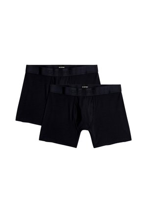Dvě černé boxerky značky G-Star s elastickými pásky, vedle sebe na bílém pozadí.