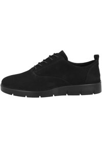 Scarpe in suede nere con lacci, punta arrotondata e suola piatta in gomma testurizzata, presentano cuciture minime e una silhouette elegante.
