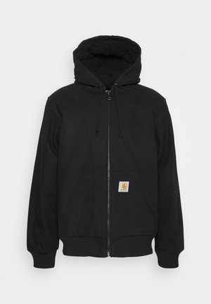 Hoodie preto com fecho zip, capucho acolchoado, cordões e bolsos frontais. Apresenta um patch de logo no bolso esquerdo e punhos canelados.