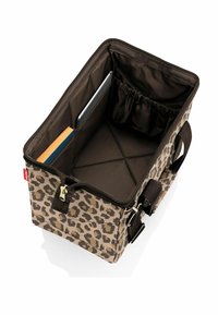 Bolso de estampado de leopardo con un interior marrón, que cuenta con un cierre de cremallera, bolsillos interiores para una tableta y un cuaderno, y asas resistentes.